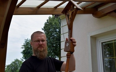 Ojciec Grzegorz Filipiuk OFMCap trzyma krzyż z relikwiami bł. o. Honorata.