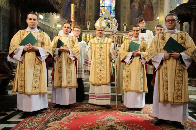 Nowo wyświęceni diakoni z biskupem Mirosławem na zakończenie liturgii święceń.
