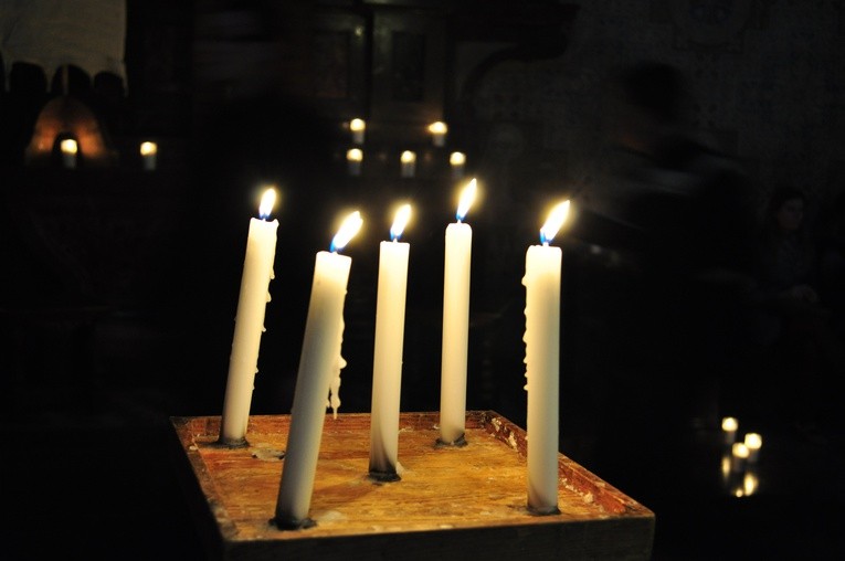 Zapalone świece w ciemnej bazylice katedralnej tworzą nastrój kontemplacji podczas tego festiwalu